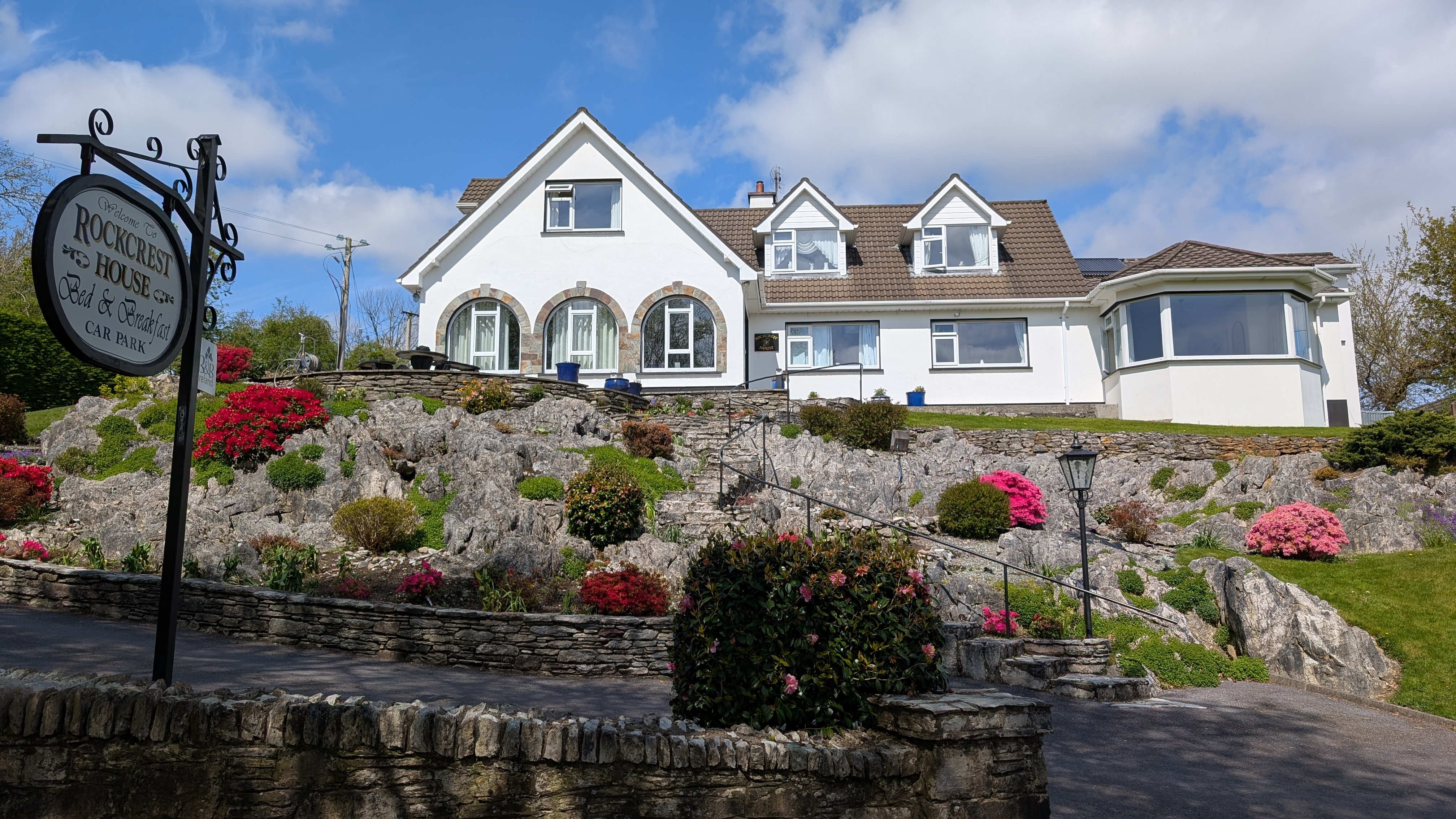 Rockcrest House B&B exterior with rock gardens and flowering azaleas