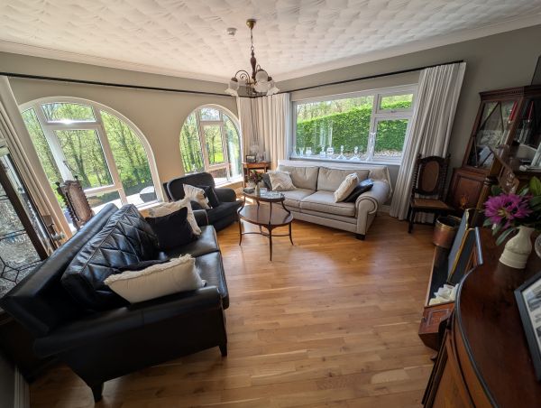 Guest lounge with arched windows and hardwood floors