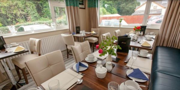 Breakfast room set for guests with garden views